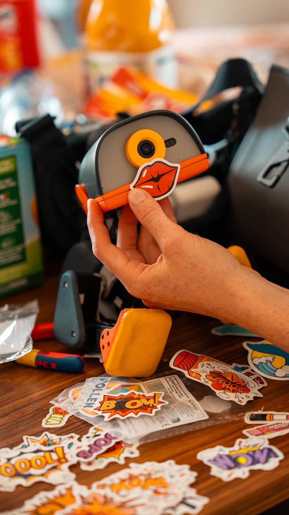 A hand pressing a die-cut decal onto a Microduck's face
